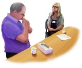 Man sat at a table with a box of tissues alongside a therapist sat in a chair